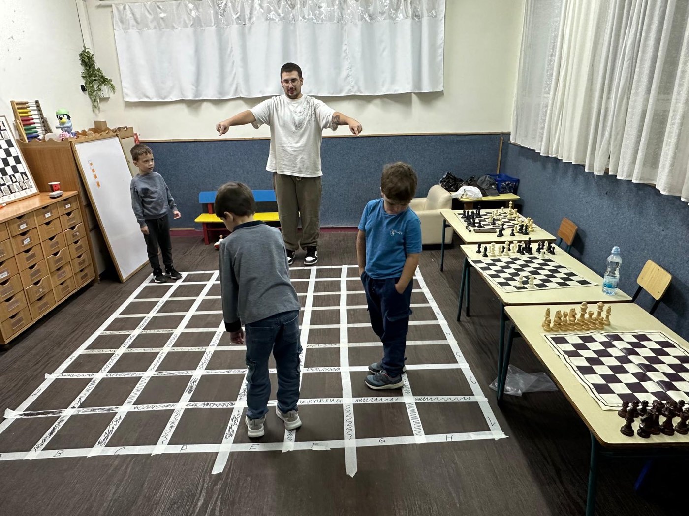 Разбор хода фигуры на шахматной доске в натуральную величину, наклеенной на полу